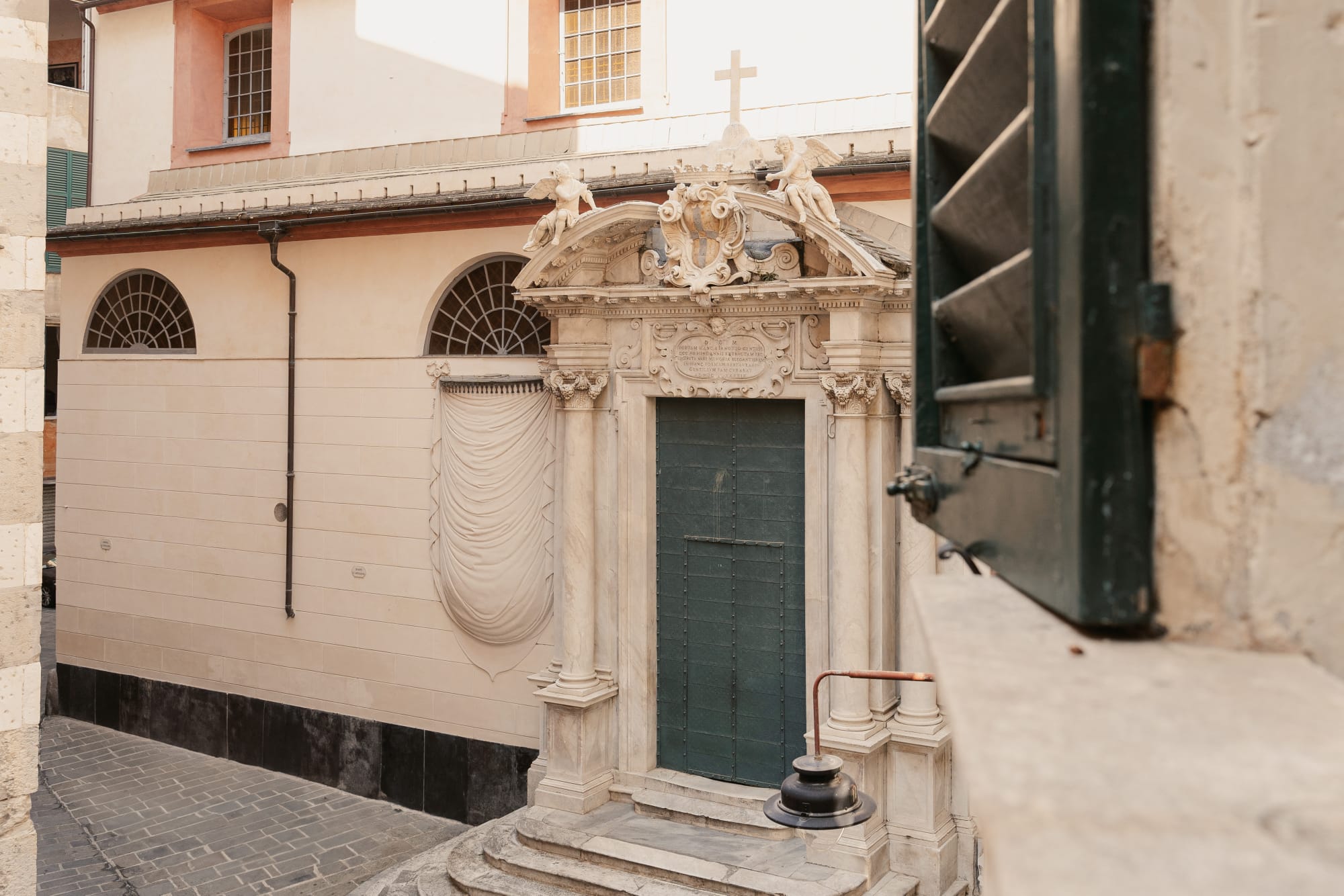 Il portale barocco con la porta verde di un palazzo genovese